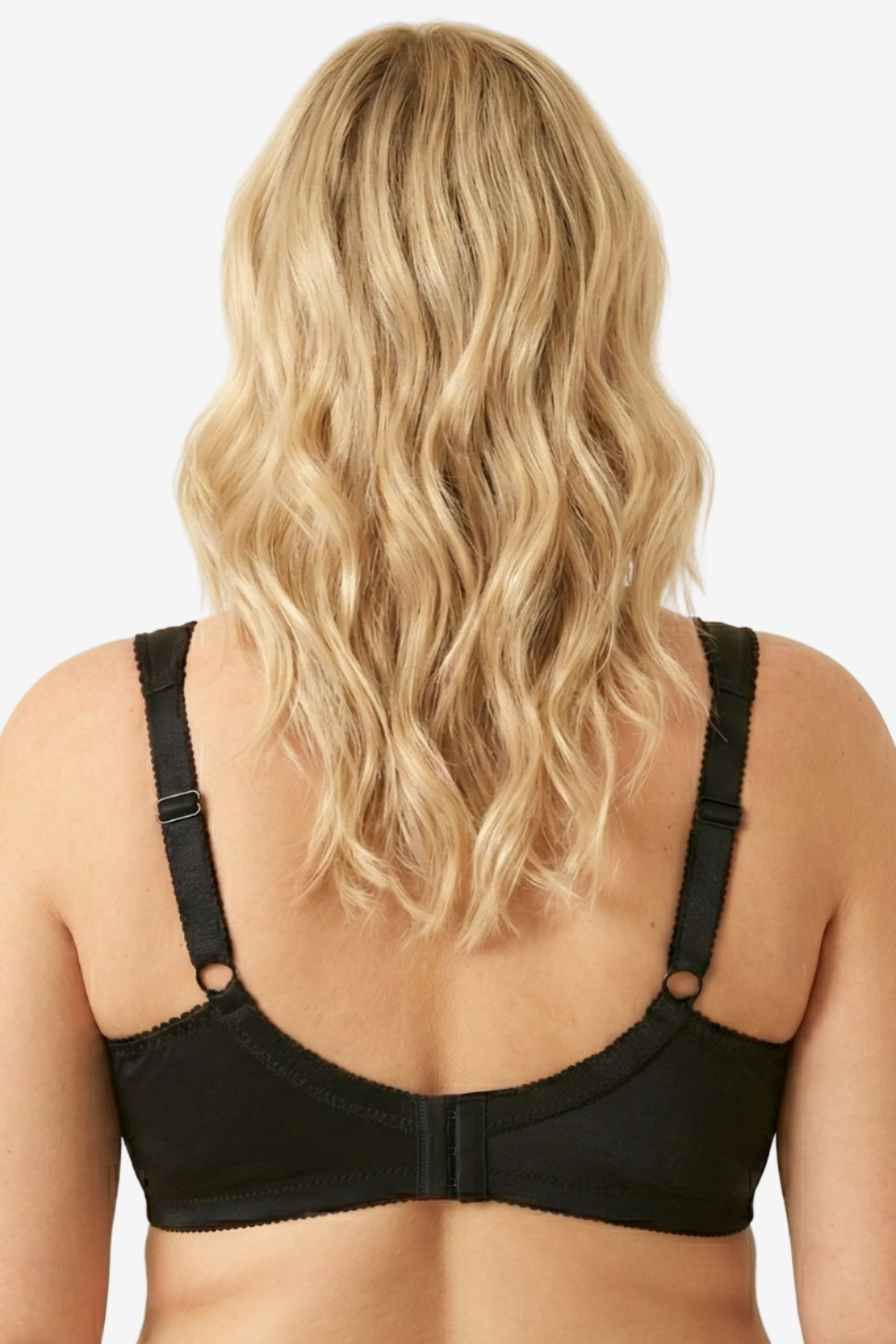 Person wearing a black bra against a beige background