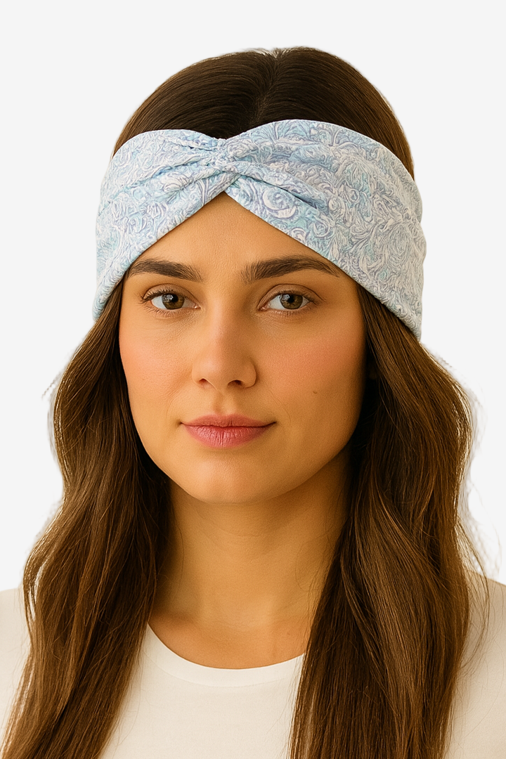 Woman wearing a light blue patterned headband against a plain background
