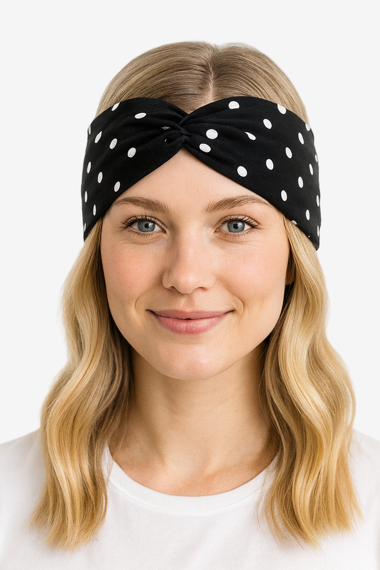 Woman wearing a black headband with white polka dots on a white background