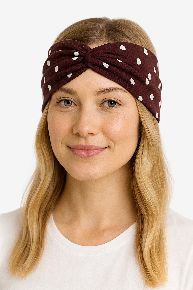Woman wearing a brown headband with white polka dots on a white background