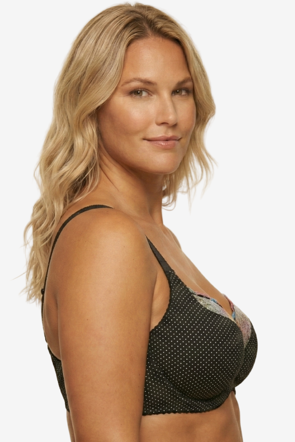 Woman wearing a black bralette with mesh details on a beige background
