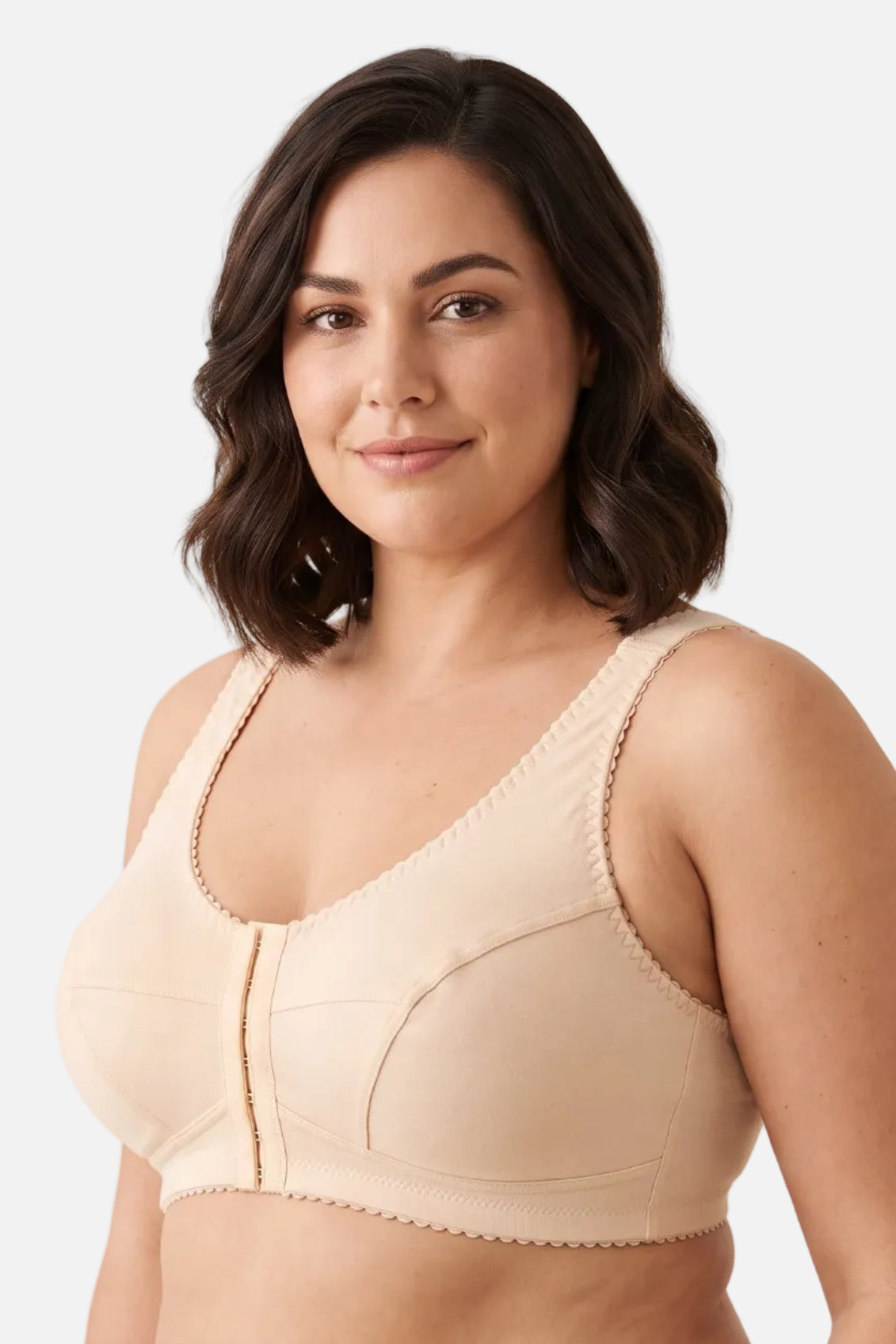 A woman modeling a beige wireless underwire bra with a center gore and scalloped edges, set against a plain off-white background.